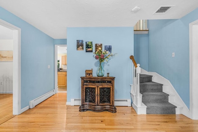 31 Alexander Rd, Hopkinton, MA 01748 - hallway with a baseboard radiator, baseboard heating, light wood-style flooring, and stairs