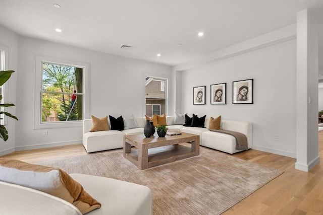 living area with light wood-style floors, recessed lighting, and baseboards