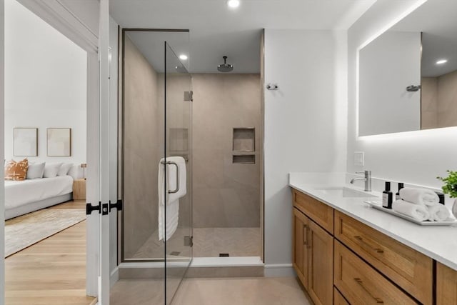 bathroom with a shower stall, vanity, ensuite bathroom, recessed lighting, and baseboards