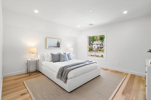 bedroom featuring baseboards, recessed lighting, and light wood-type flooring