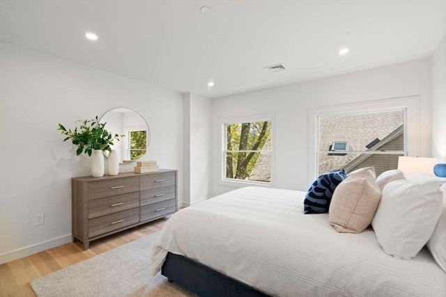 bedroom with light wood-type flooring, baseboards, and recessed lighting