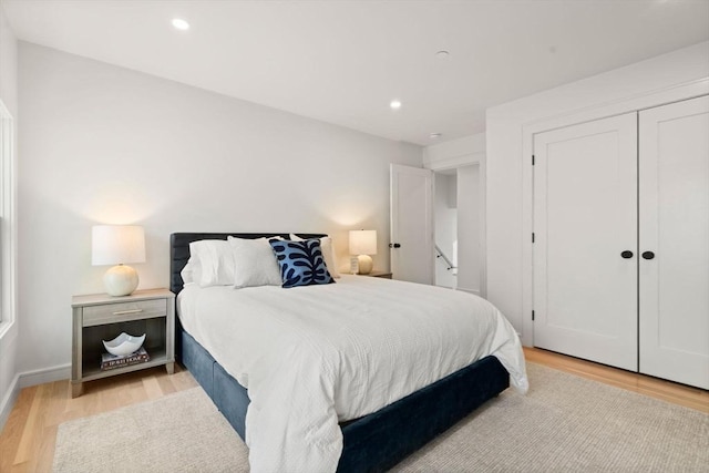bedroom featuring light wood-type flooring, recessed lighting, and a closet