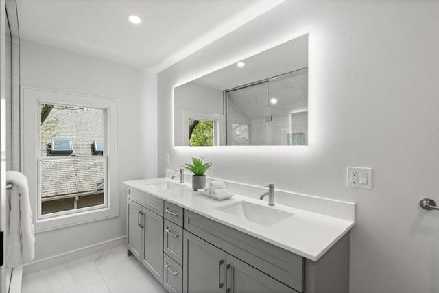 bathroom featuring marble finish flooring, recessed lighting, a shower with door, baseboards, and double vanity