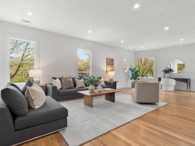 living area with plenty of natural light, recessed lighting, light wood-style flooring, and baseboards