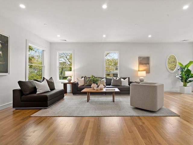 living room with healthy amount of natural light, recessed lighting, wood finished floors, and baseboards