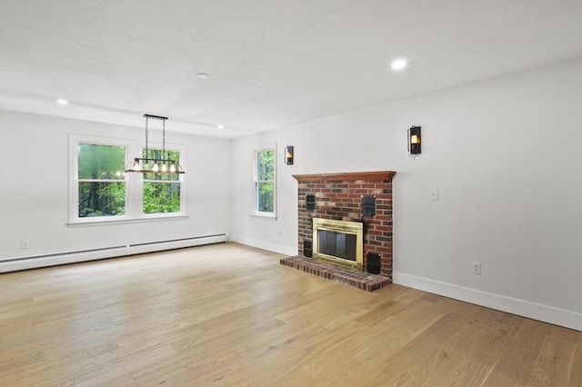455 Main St, Rutland, MA 01543 - unfurnished living room featuring baseboard heating, wood finished floors, baseboards, a brick fireplace, and a chandelier