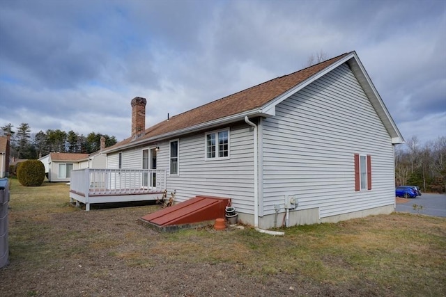 rear view of property featuring a lawn and a deck