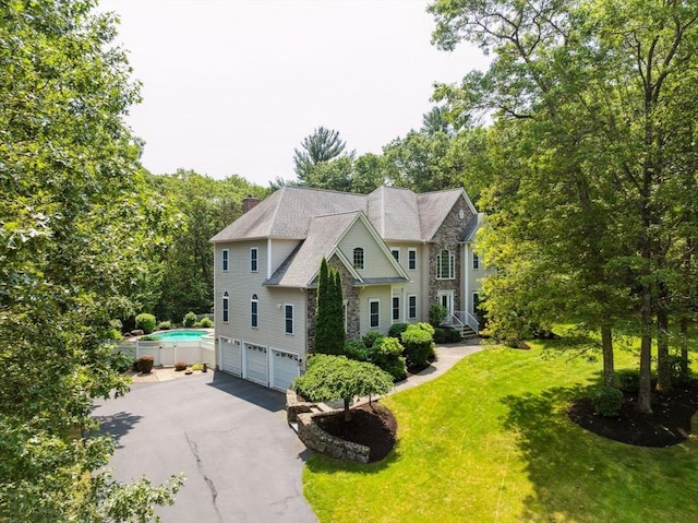 20 October Dr, Franklin, MA 02038 - view of property exterior featuring a garage, asphalt driveway, a lawn, and stone siding