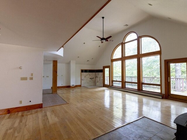 unfurnished living room with light wood-type flooring, high vaulted ceiling, a baseboard heating unit, and ceiling fan