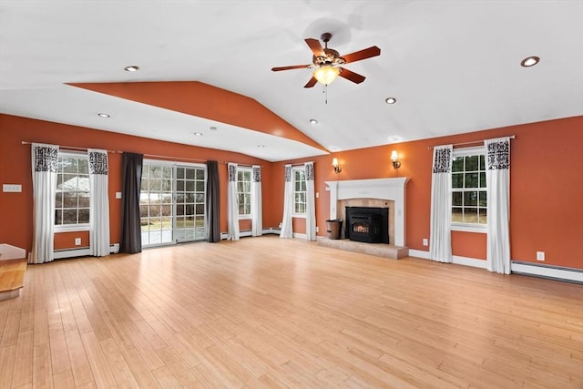 unfurnished living room with ceiling fan, lofted ceiling, baseboard heating, light wood-style flooring, and a fireplace