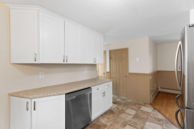 kitchen with white cabinetry, a wainscoted wall, and stainless steel appliances