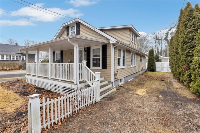 bungalow with covered porch and fence