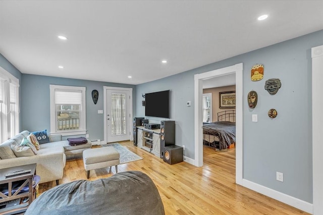 living area featuring recessed lighting, light wood-type flooring, baseboard heating, and baseboards