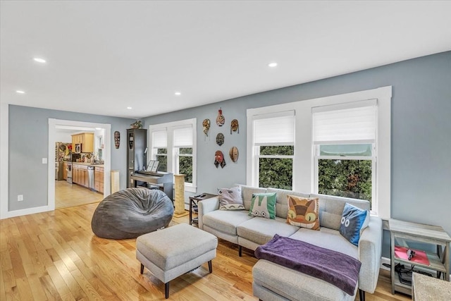 living room with recessed lighting, baseboards, and light wood-style floors