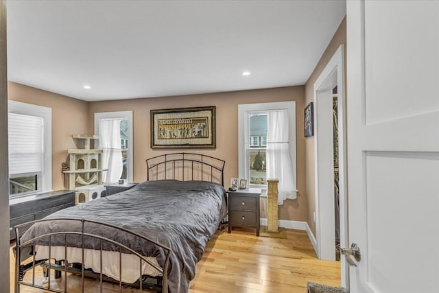 bedroom featuring light wood finished floors, recessed lighting, and baseboards