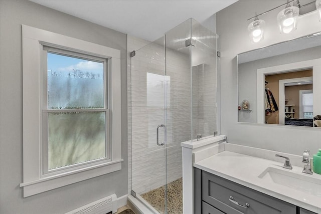 full bath featuring baseboard heating, a stall shower, and vanity