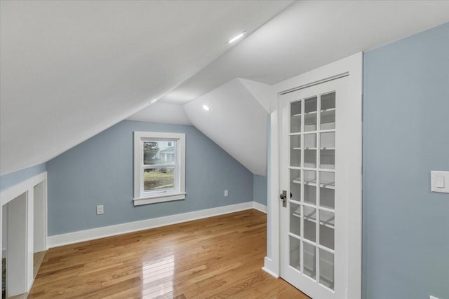 bonus room with baseboards, wood finished floors, and vaulted ceiling