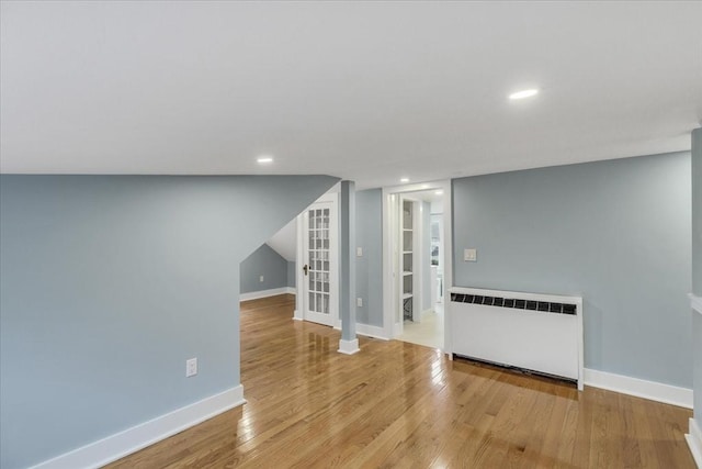 interior space featuring recessed lighting, radiator, wood finished floors, and baseboards