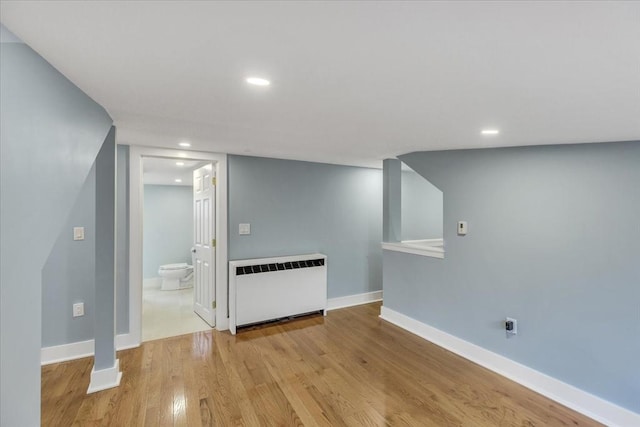 interior space with recessed lighting, radiator heating unit, wood finished floors, and baseboards