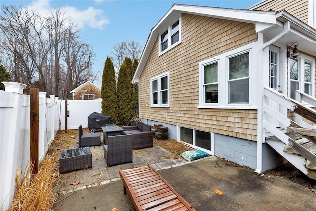 view of patio / terrace featuring a garage, a grill, an outdoor hangout area, and a fenced backyard