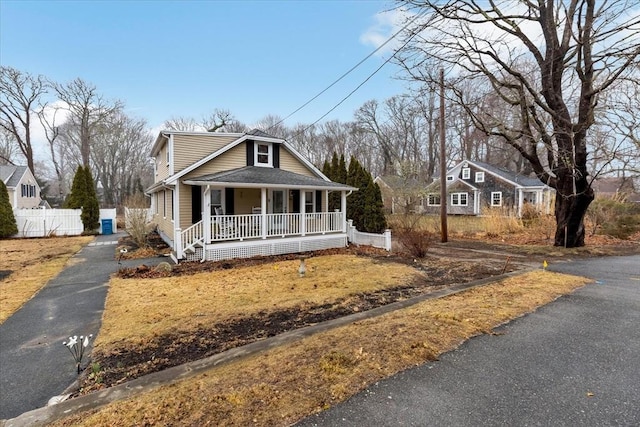 bungalow-style house featuring covered porch and fence