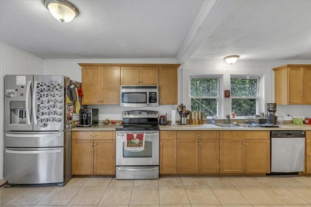 kitchen featuring light tile patterned flooring, stainless steel appliances, light countertops, and a sink