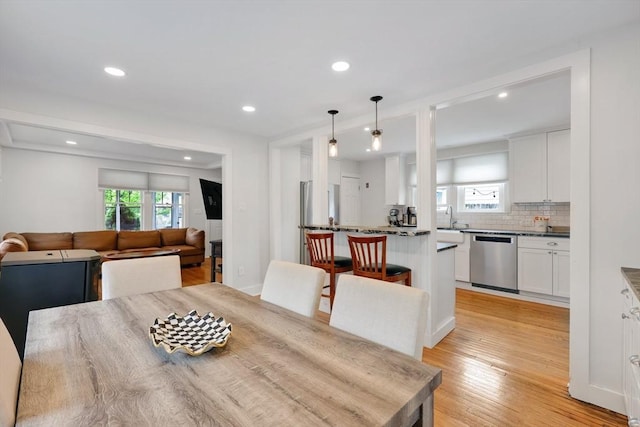dining area featuring light wood finished floors and recessed lighting