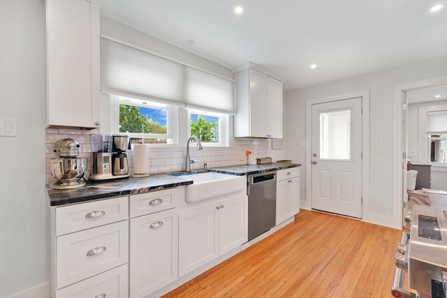 kitchen featuring dishwasher, a sink, light wood-style flooring, backsplash, and white cabinets