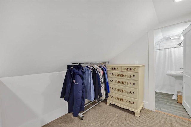 walk in closet with vaulted ceiling and carpet