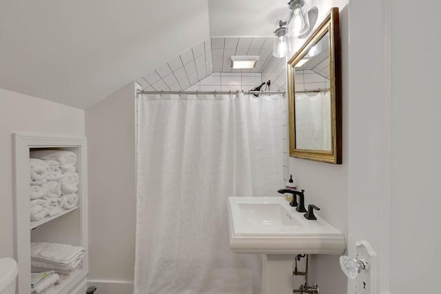 bathroom featuring a shower with curtain, a sink, and toilet