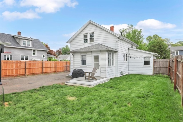 back of property with a chimney and a deck