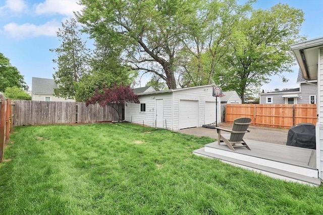 view of yard with an outbuilding, a detached garage, and a deck