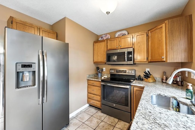 50 Waters Edge Unit 50, Ludlow, MA 01056 - kitchen with appliances with stainless steel finishes, light tile patterned floors, and a textured ceiling