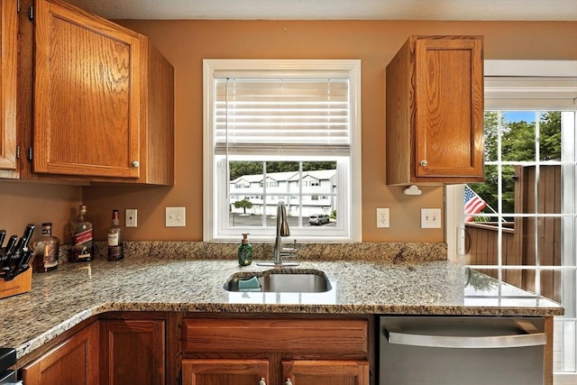 50 Waters Edge Unit 50, Ludlow, MA 01056 - kitchen with stainless steel dishwasher, brown cabinets, and light stone countertops