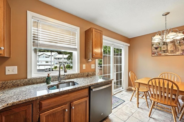 50 Waters Edge Unit 50, Ludlow, MA 01056 - kitchen with stainless steel dishwasher, brown cabinets, hanging light fixtures, light stone counters, and light tile patterned floors