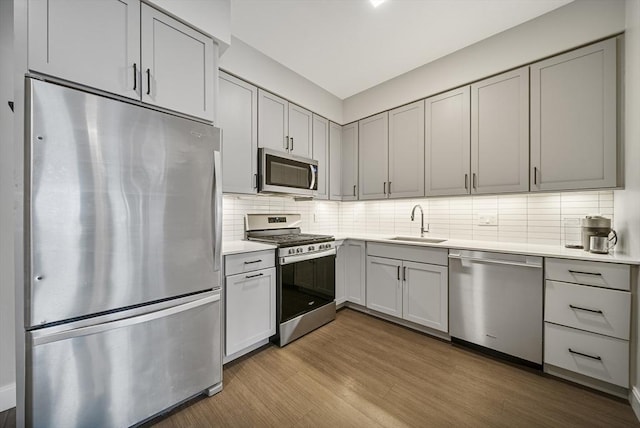 11 Walley St Unit 202, Boston, MA 02128 - kitchen featuring appliances with stainless steel finishes, a sink, gray cabinets, light countertops, and tasteful backsplash