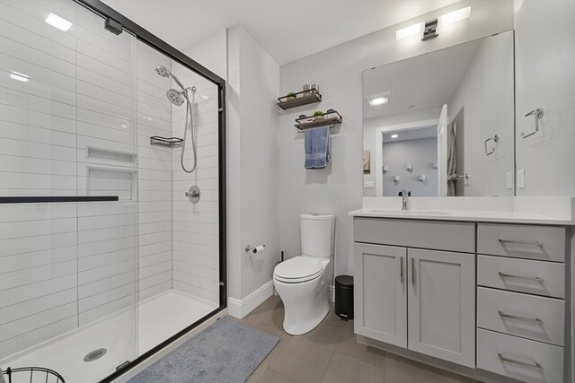 bathroom featuring tile patterned floors, walk in shower, vanity, and toilet