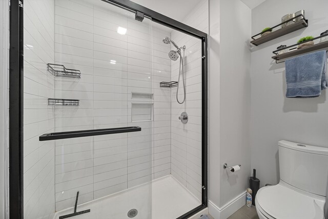 bathroom featuring an enclosed shower and toilet