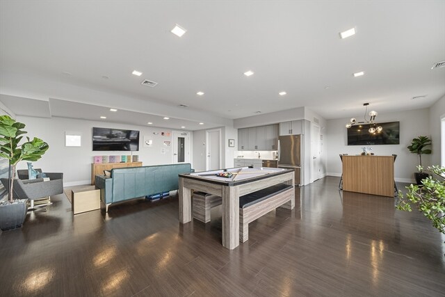 game room with a notable chandelier, dark hardwood / wood-style flooring, and billiards