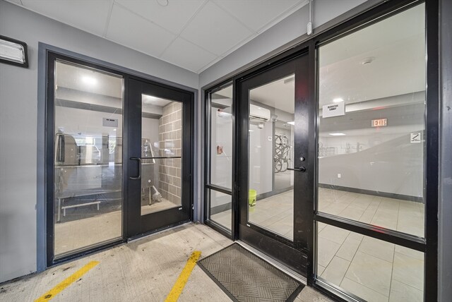 doorway to outside featuring a wall unit AC and french doors