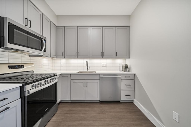 11 Walley St Unit 202, Boston, MA 02128 - kitchen featuring stainless steel appliances, gray cabinets, a sink, dark wood-style flooring, and backsplash