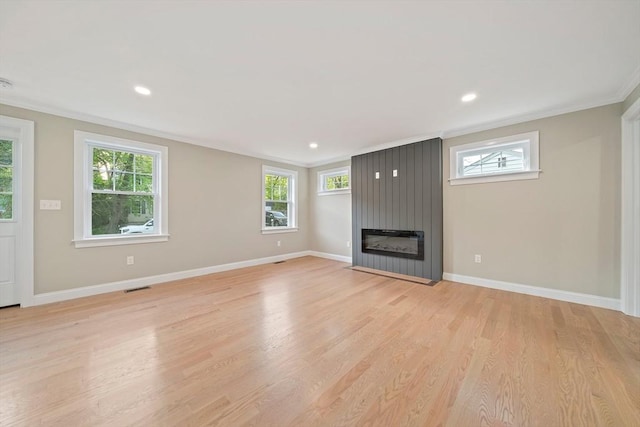 56 Lake St, Braintree, MA 02184 - unfurnished living room with crown molding, a fireplace, light wood-style flooring, healthy amount of natural light, and baseboards