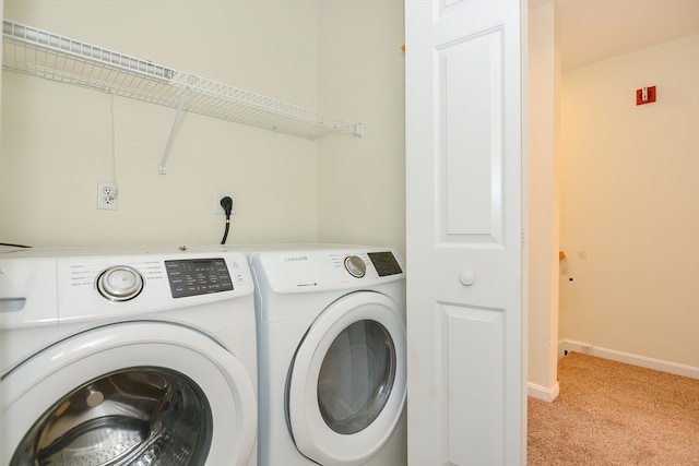 clothes washing area featuring washing machine and dryer and light colored carpet