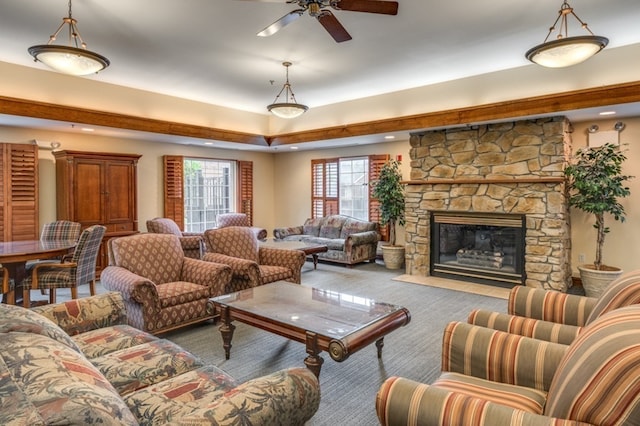 living room with carpet, a stone fireplace, and ceiling fan