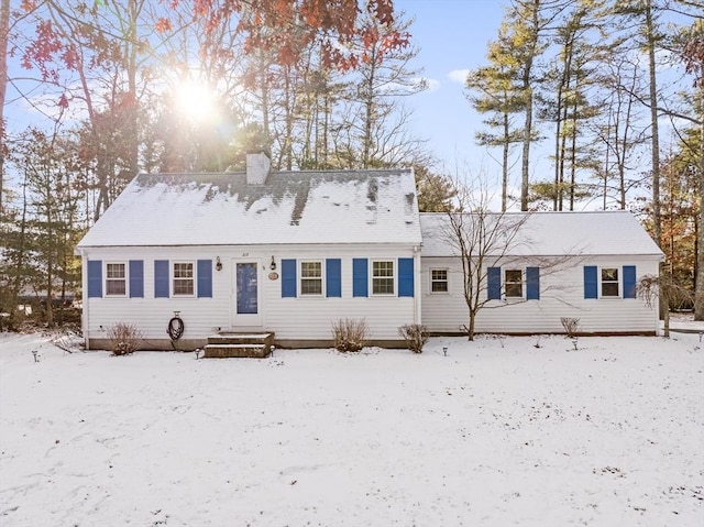 snow covered property with a chimney