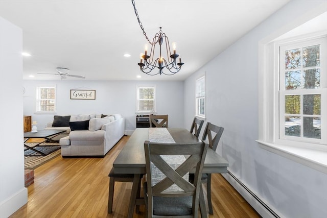 dining room with a baseboard radiator, a chandelier, and light hardwood / wood-style floors