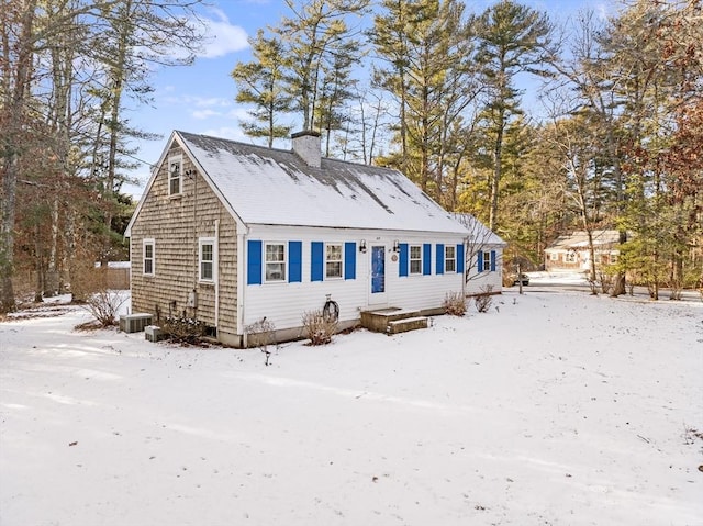 view of front of house with central AC unit and a chimney