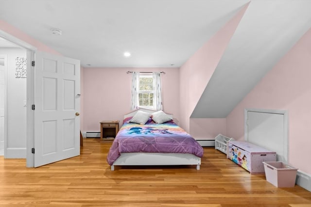 bedroom with a baseboard radiator and light wood-type flooring