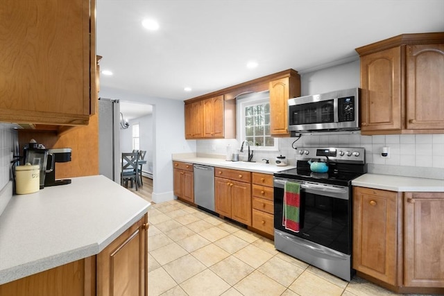 kitchen featuring stainless steel appliances, tasteful backsplash, sink, and light tile patterned floors