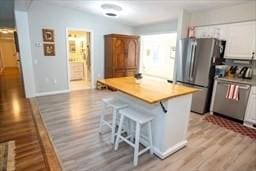 185 Baldwinville Rd, Winchendon, MA 01475 - kitchen with freestanding refrigerator, light wood-type flooring, a breakfast bar area, a kitchen island, and baseboards